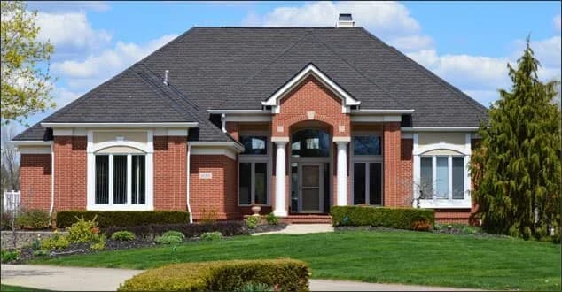 A large brick San Diego home with a freshly installed asphalt shingle roof.