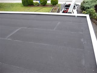 A flat membrane commercial roof with a parapet edge.