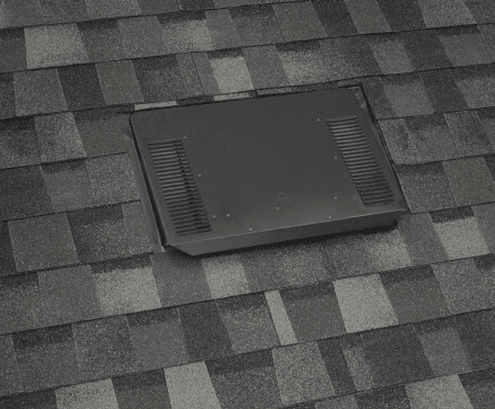 A low-profile ember-resistant attic vent installed nearly flush on a multi-tone asphalt shingle roof.